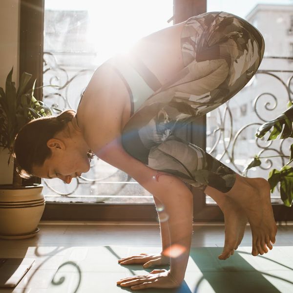 Woman practicing a dynamic yoga flow in a calm setting.